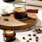 Clear espresso shot glass with handle on wooden surface