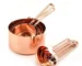 Set of stainless steel measuring cups with copper and rose gold finishes on wooden stand