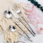 Matte gold flatware set with antique finish arranged on a wooden table