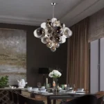 Smoky gray chandelier with glass bubbles hanging over a modern dining table
