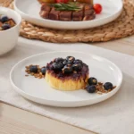 Elegant ceramic plates set with dinner plates, dessert plates, cereal bowls, and soup bowls arranged on a wooden table