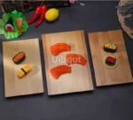 Bamboo sushi serving tray with assorted sushi rolls and sashimi on a wooden table
