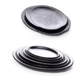 Black melamine dinner plates stacked elegantly on a wooden table