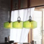 Modern colored glass pendant lamp illuminating a cozy dining room with vibrant hues