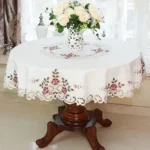 Elegant lace tablecloth with rose gold embroidery on a dining table