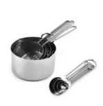 Set of stainless steel measuring cups with copper and rose gold finishes on wooden stand