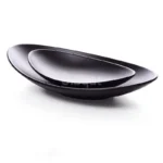 Black melamine dinner plates stacked elegantly on a wooden table