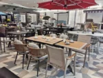 French retro oval dining table with natural wood top and teak base in a dining room setting