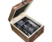 Old fashioned glass set with whiskey tumblers, ice stones, and wooden gift box on a rustic table