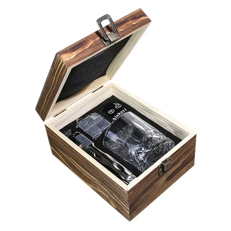 Old fashioned glass set with whiskey tumblers, ice stones, and wooden gift box on a rustic table