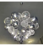 Smoky gray chandelier with glass bubbles hanging over a modern dining table