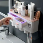 Automatic toothpaste dispenser dispensing paste onto a toothbrush, with the holder in background.