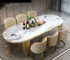 Elegant oval marble dining table with gold stainless steel legs in a modern dining room setting