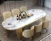 Elegant oval marble dining table with gold stainless steel legs in a modern dining room setting
