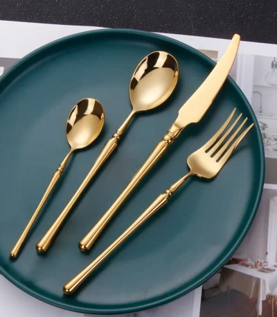 Matte gold flatware set with antique finish arranged on a wooden table