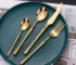 Matte gold flatware set with antique finish arranged on a wooden table