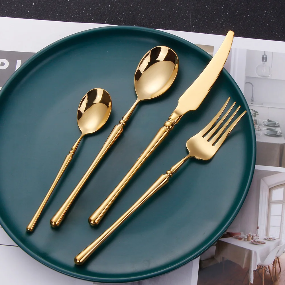 Matte gold flatware set with antique finish arranged on a wooden table