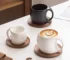Elegant ceramic coffee mug set with saucer on wooden table, featuring oat-colored cups