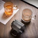 Japanese-style vertical stripes bamboo lid drinking glass with handle on wooden table