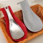 Silicone spoon rest holding a wooden spoon on a kitchen counter