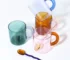 Borosilicate glass mug with coffee and glass spoon on a wooden table