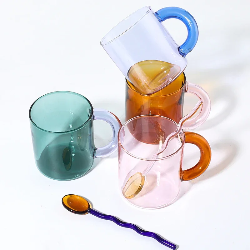 Borosilicate glass mug with coffee and glass spoon on a wooden table