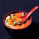 Japanese style ramen bowl set with melamine bowls, spoons, and noodle cups on a table