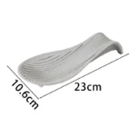 Silicone spoon rest holding a wooden spoon on a kitchen counter