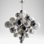 Smoky gray chandelier with glass bubbles hanging over a modern dining table