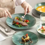 Vancasso KARST green stoneware dinner set with embossed plates and bowls on a rustic wooden table