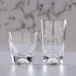 Transparent snow mountain whiskey glasses with Mount Fuji shape on a wooden table