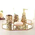 Goldoma ceramic toothbrush holder in golden finish, standing alone on marble surface.