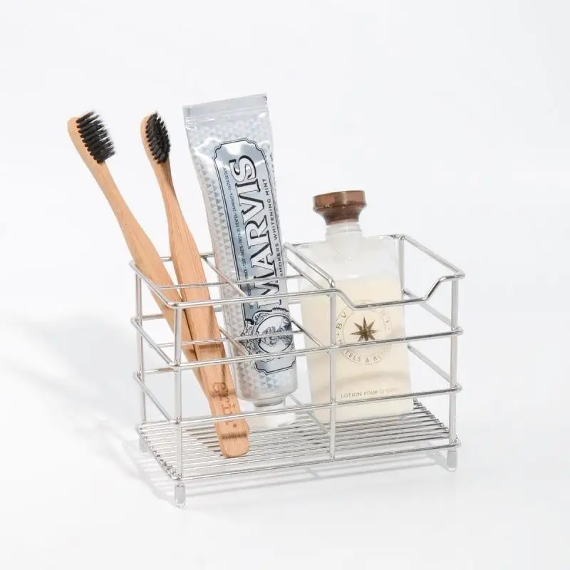 Creative stainless steel toothbrush holder in black, wall-mounted, holding two toothbrushes and a toothpaste tube.