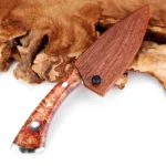 Damascus steel cleaver with wooden sheath on cutting board