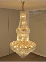 Modern crystal chandelier for dining room hanging over a wooden table with warm glow