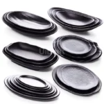 Black melamine dinner plates stacked elegantly on a wooden table