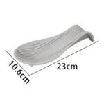 Silicone spoon rest holding a wooden spoon on a kitchen counter