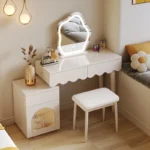 Modern makeup vanity desk with mirror and stool in a bedroom setting, showcasing ample storage and elegant design
