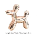 Ceramic balloon dog in a gold finish on a marble countertop.
