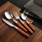 4-piece stainless steel flatware set with sapele wooden handles on a table