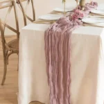 Boho cheesecloth table runner and napkins set as rustic table linens on a wooden table