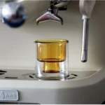 Clear double wall insulated glass mug with espresso coffee on wooden table