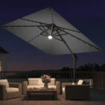 Goldoma large patio umbrella with lights illuminating a 9x9 FT square cantilever umbrella with solar LED lights in a bac