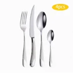Elegant gold flatware set with steak knife, fork, and spoon on a dark table