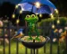 Solar frog garden light with umbrella illuminating a flower bed at dusk
