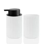 Foam soap dispenser on a farmhouse sink counter with a towel and decorative jar.