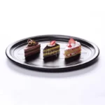 Black melamine dinner plates stacked elegantly on a wooden table