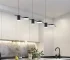 Modern chandelier dining room with minimalist branch design hanging above a wooden table