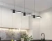 Modern chandelier dining room with minimalist branch design hanging above a wooden table