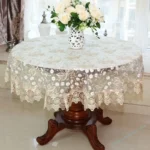 Elegant lace tablecloth with rose gold embroidery on a dining table